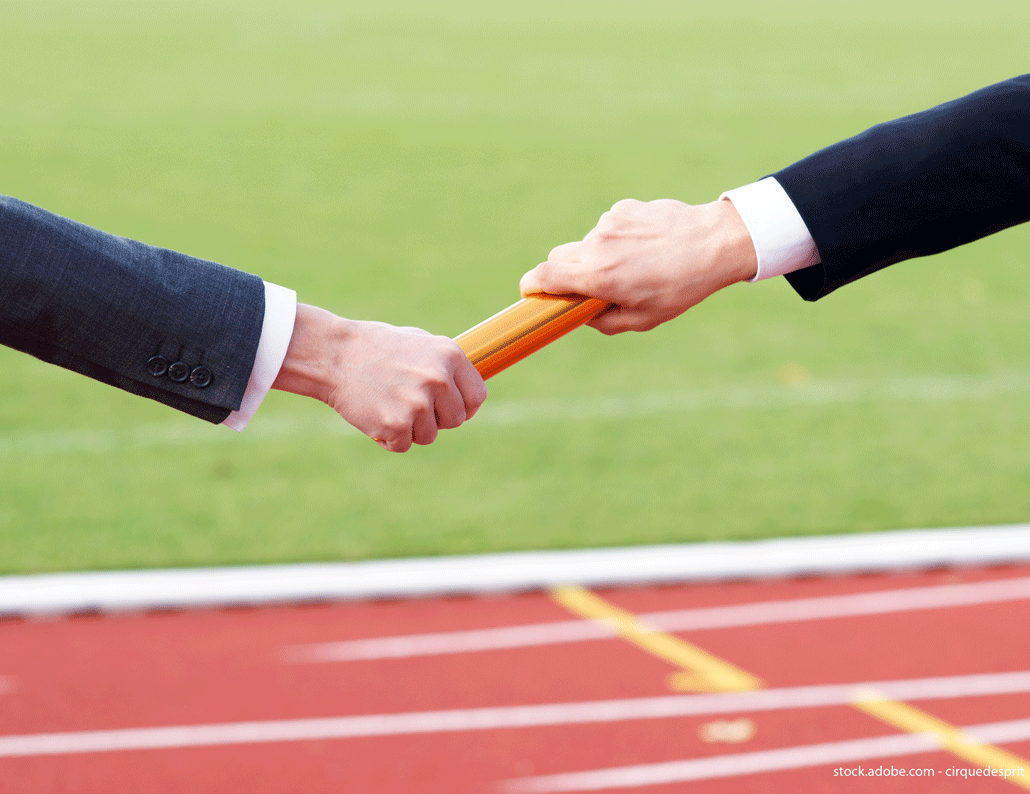 Deux mains se passent un relai avec un bâton. C'est une représentation de ce qu'est une succession transfrontalière ou non.