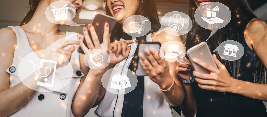 3 femmes en train de sourire en se montrant leur téléphone