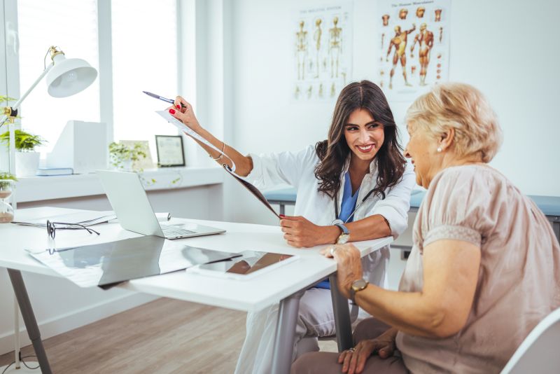 Eine Rentnerin lässt sich Untersuchungsergebnisse von einer Ärztin erklären.