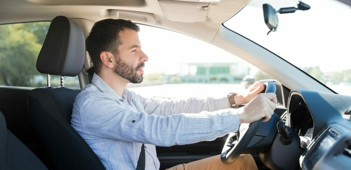 Seitenansicht eines Mannes, der im Auto unterwegs ist.