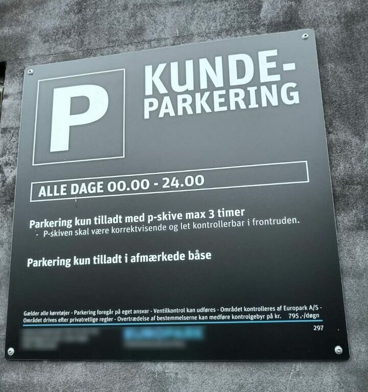 Schild mit AGB auf einem Supermarktparkplatz in Dänemark.